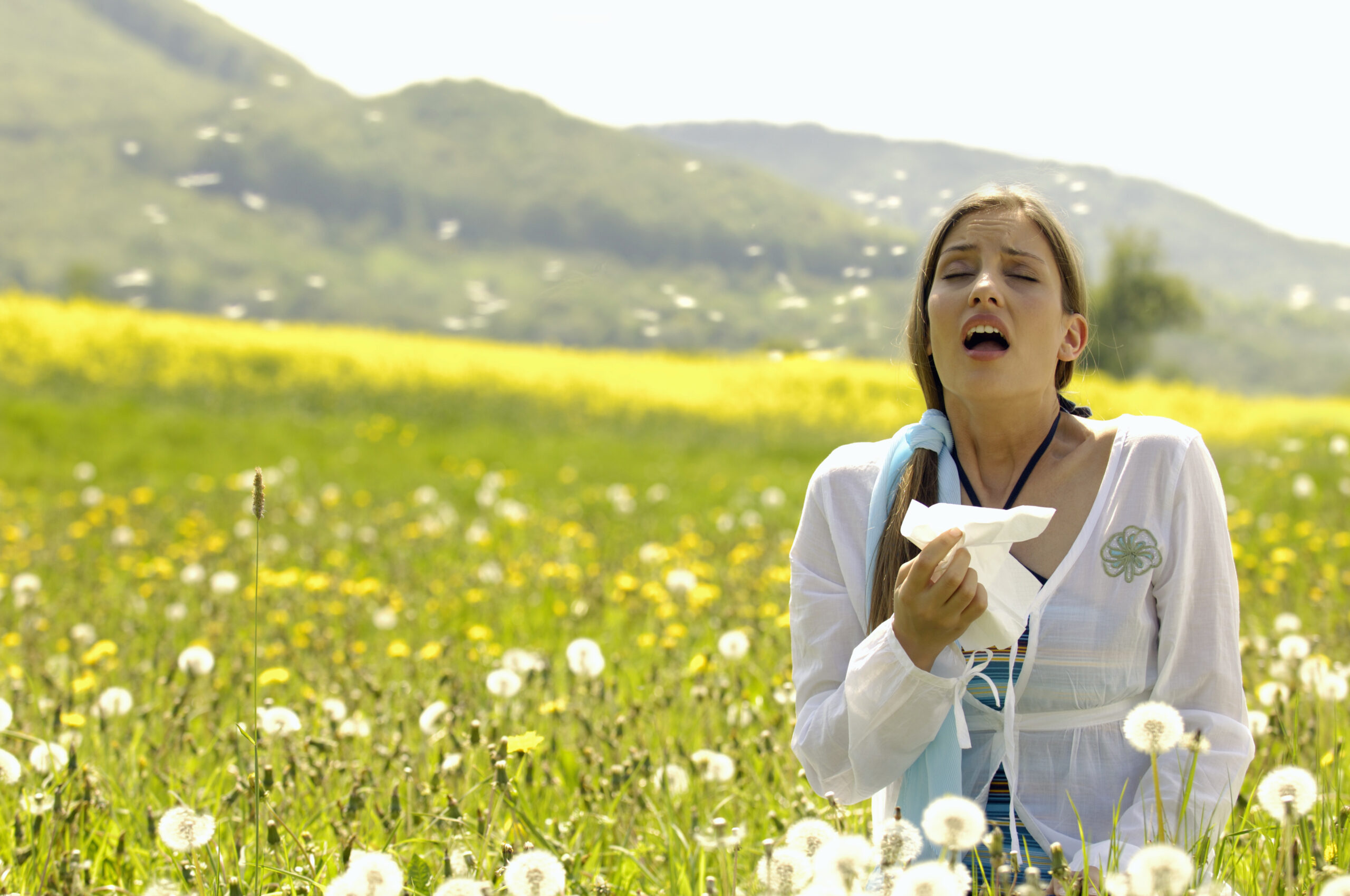 Woman,Sneezing,With,Tissue,In,Meadow